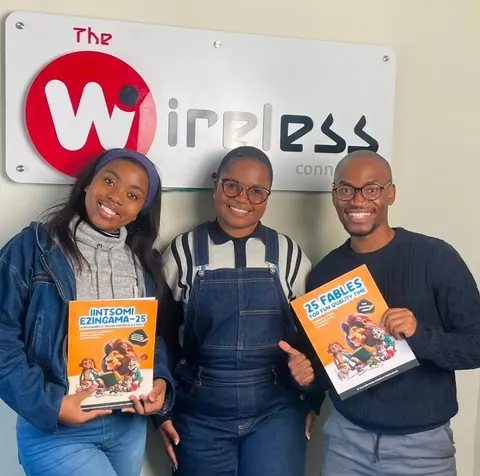 Anelisa Kana, Andisiwe Mbelekane und Lwamkelo Tshikini halten englische und isiXhosa-Bücher von FableReads bei The Wireless.